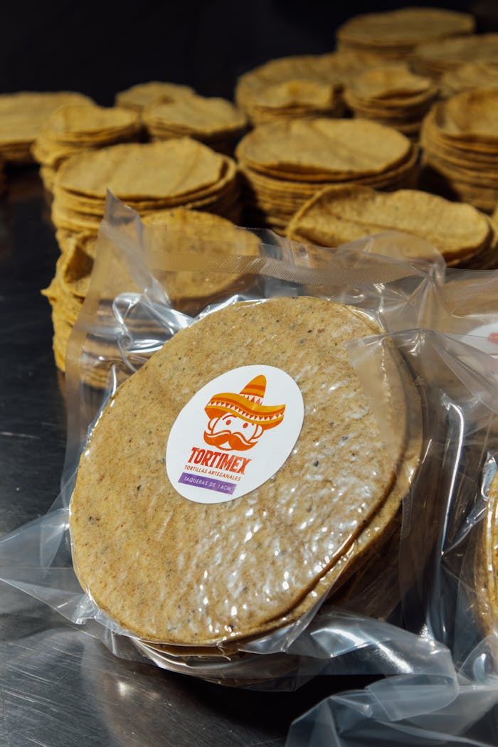 Close-up of packaged tortillas in a production line, tortilla branding visible.